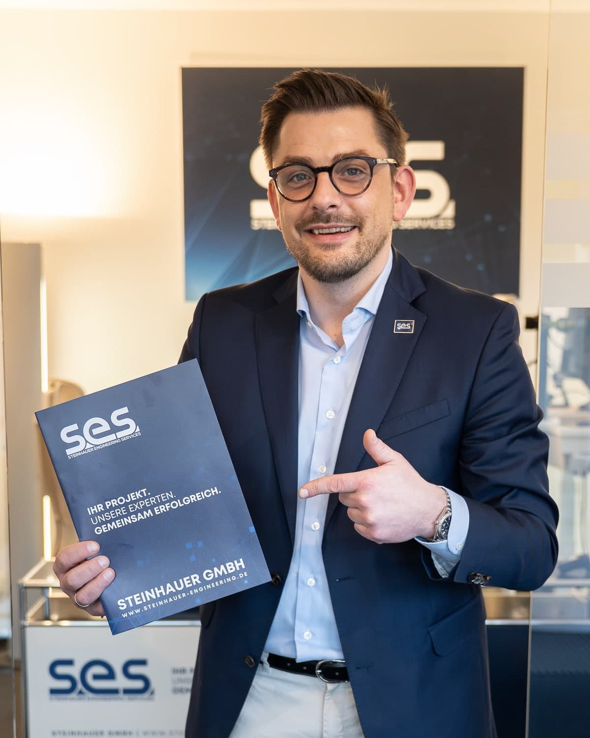 Julius Steinhauer, Geschäftsführer, im Büro mit einer Mappe der Steinhauer GmbH, auf die er zeigt